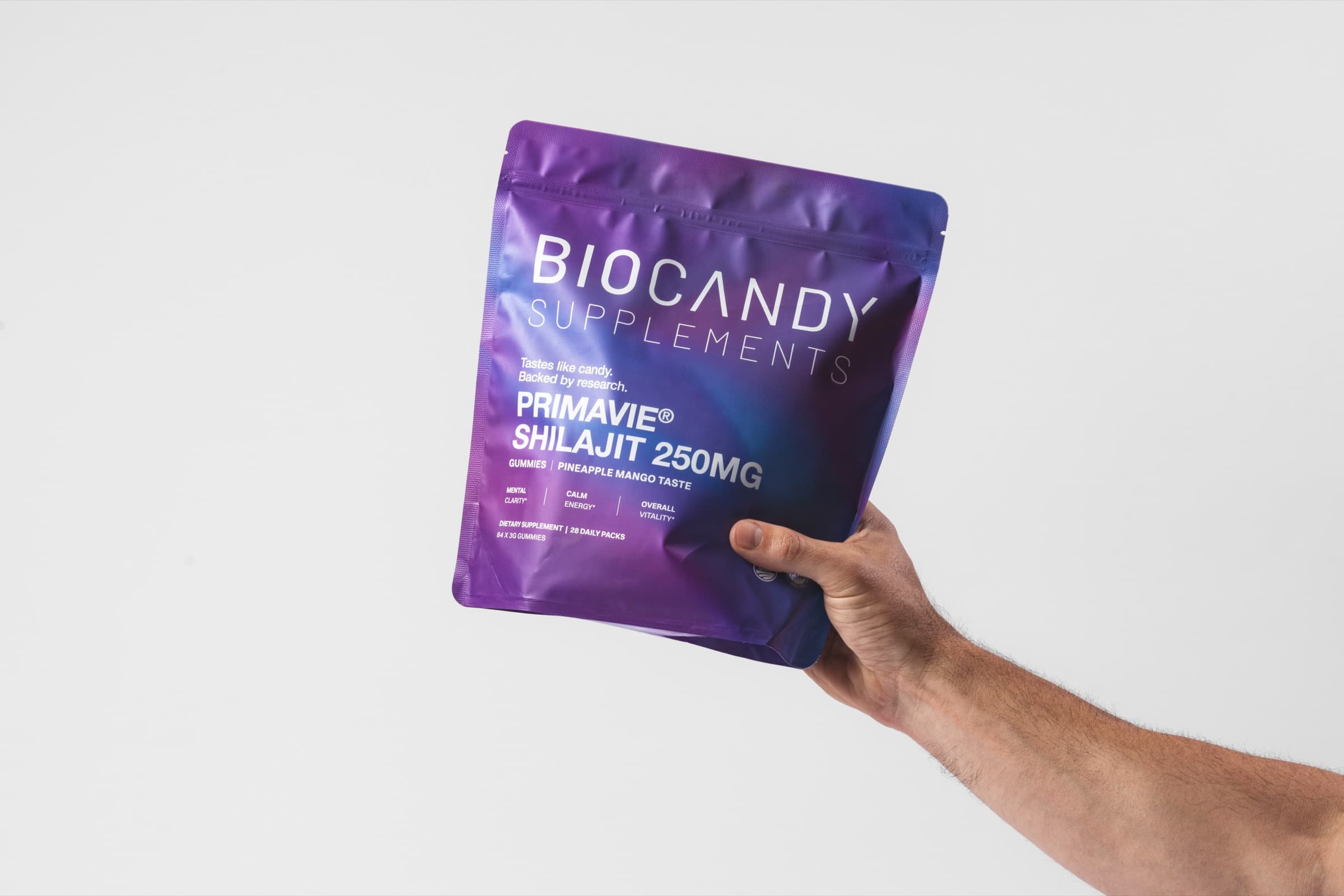 Hand holding a BioCandy PrimaVie Shilajit gummies pouch