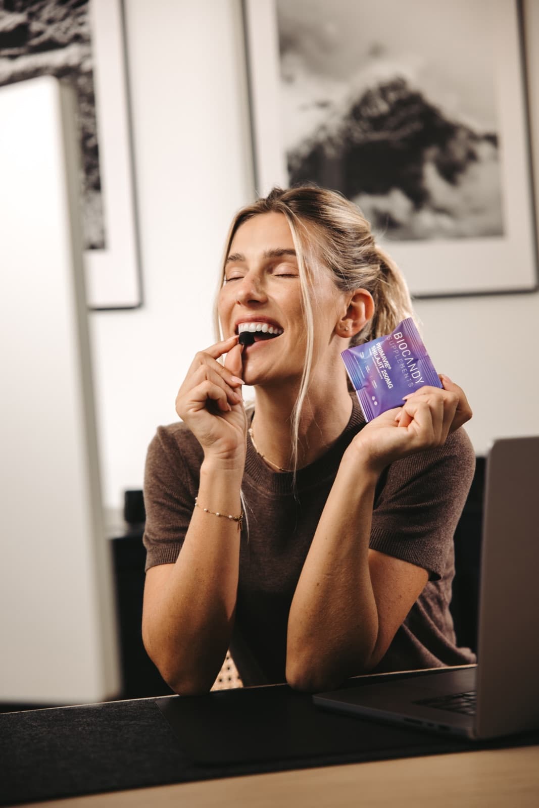 A BioCandy customer enjoying a PrimaVie Shilajit gummy at her desk