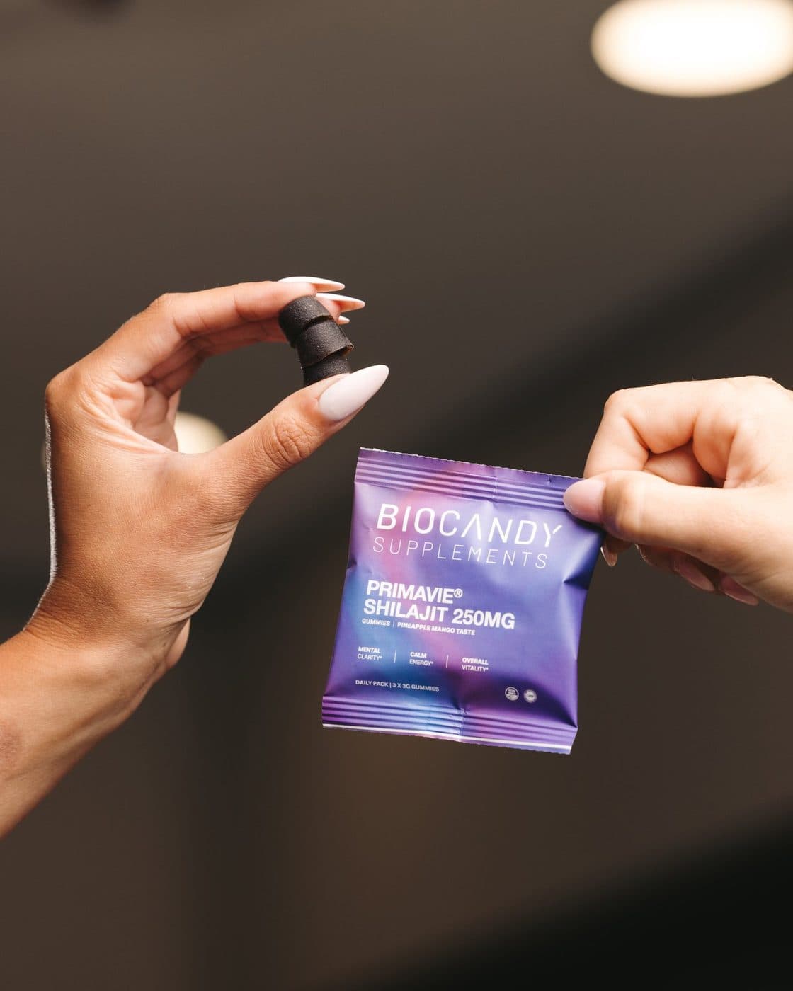 Hands holding a BioCandy PrimaVie Shilajit daily pack